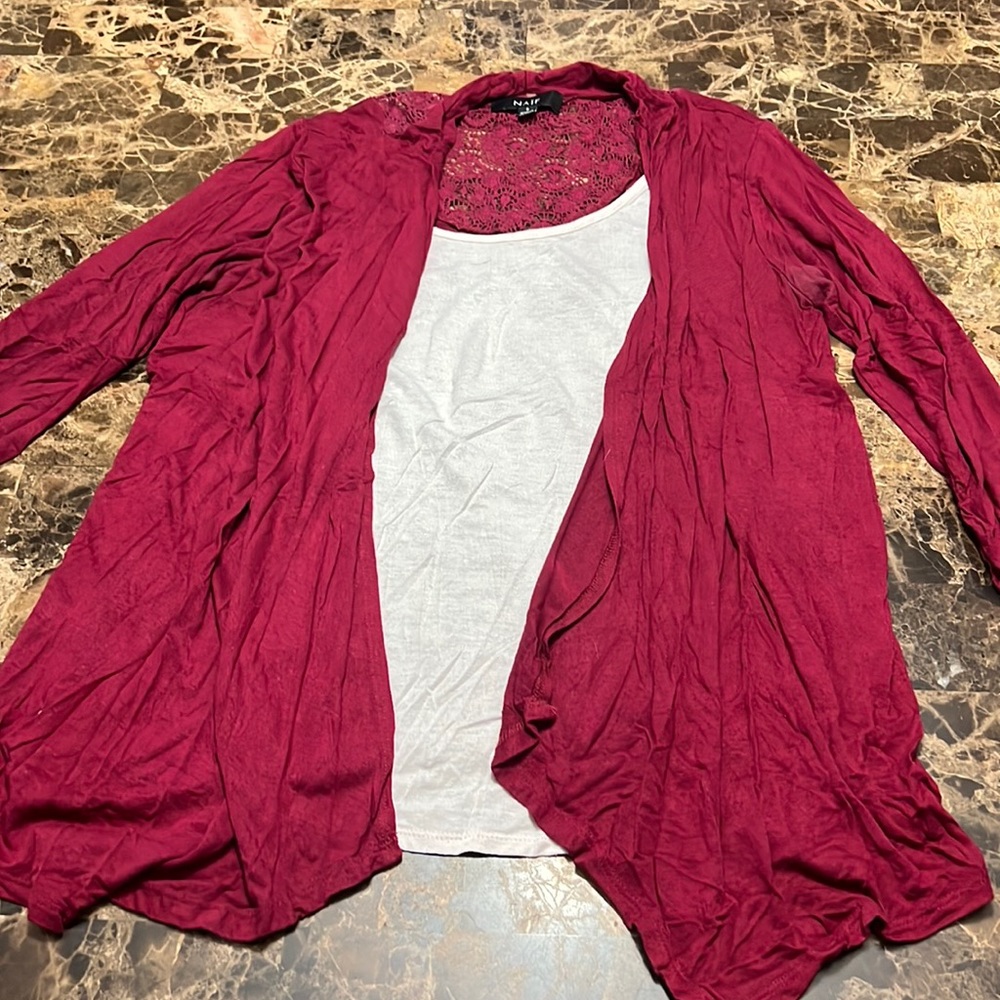 A white shirt with an attached red/purple quarter length sleeve sweater